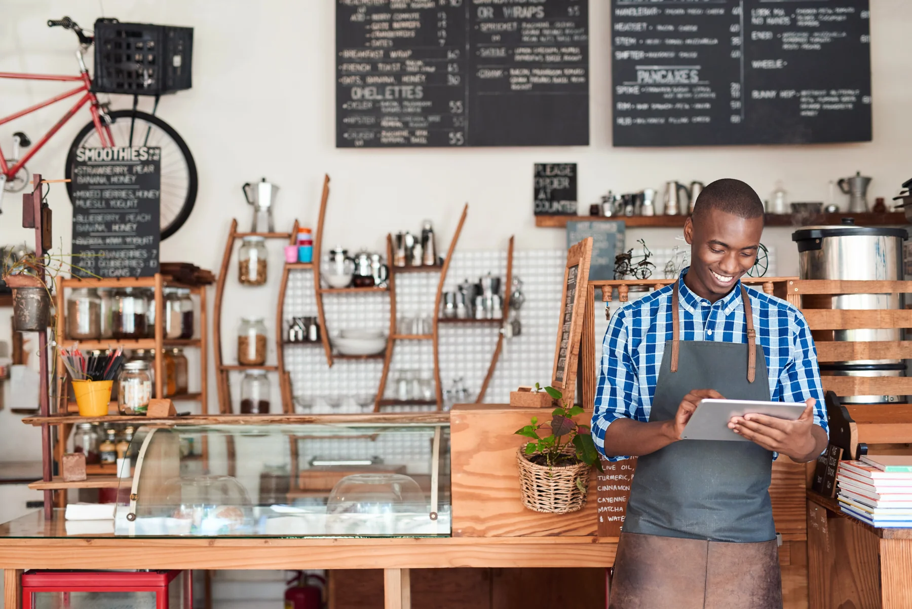 Café owner checking a tablet behind the counter.
